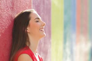 Young woman smiling and breathing well after a septorhinoplasty procedure.