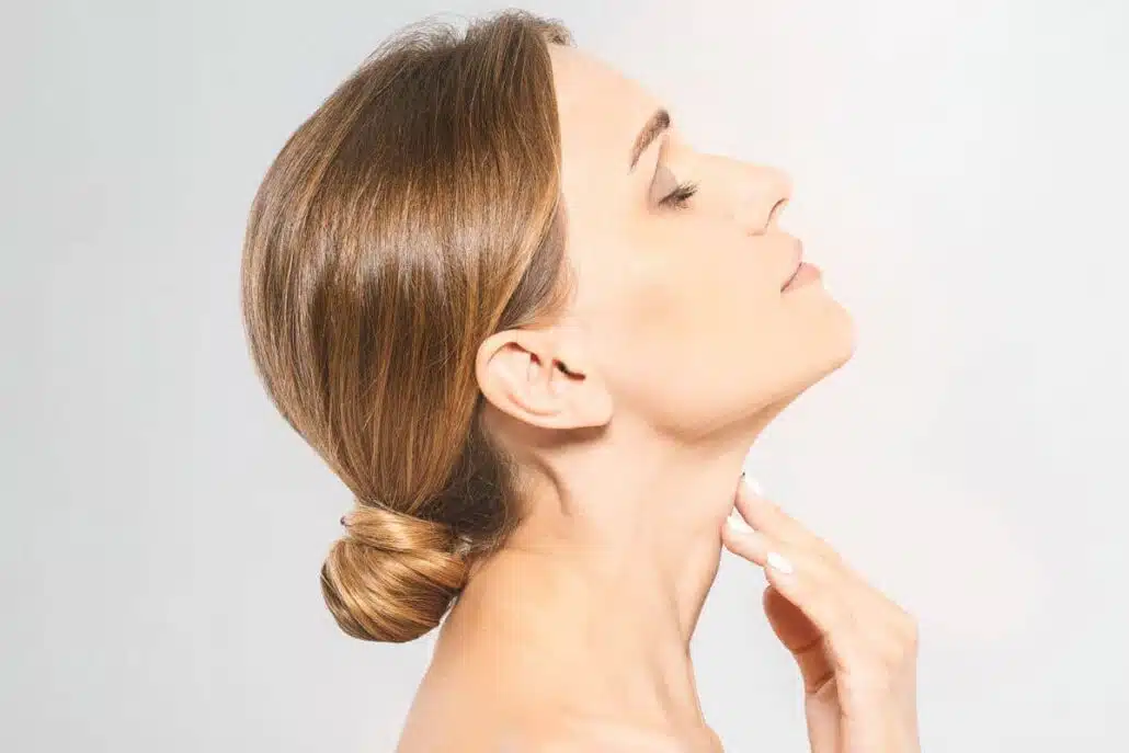 Side profile of woman with smooth neck and defined jawline, showcasing mini facelift benefits and subtle enhancement.