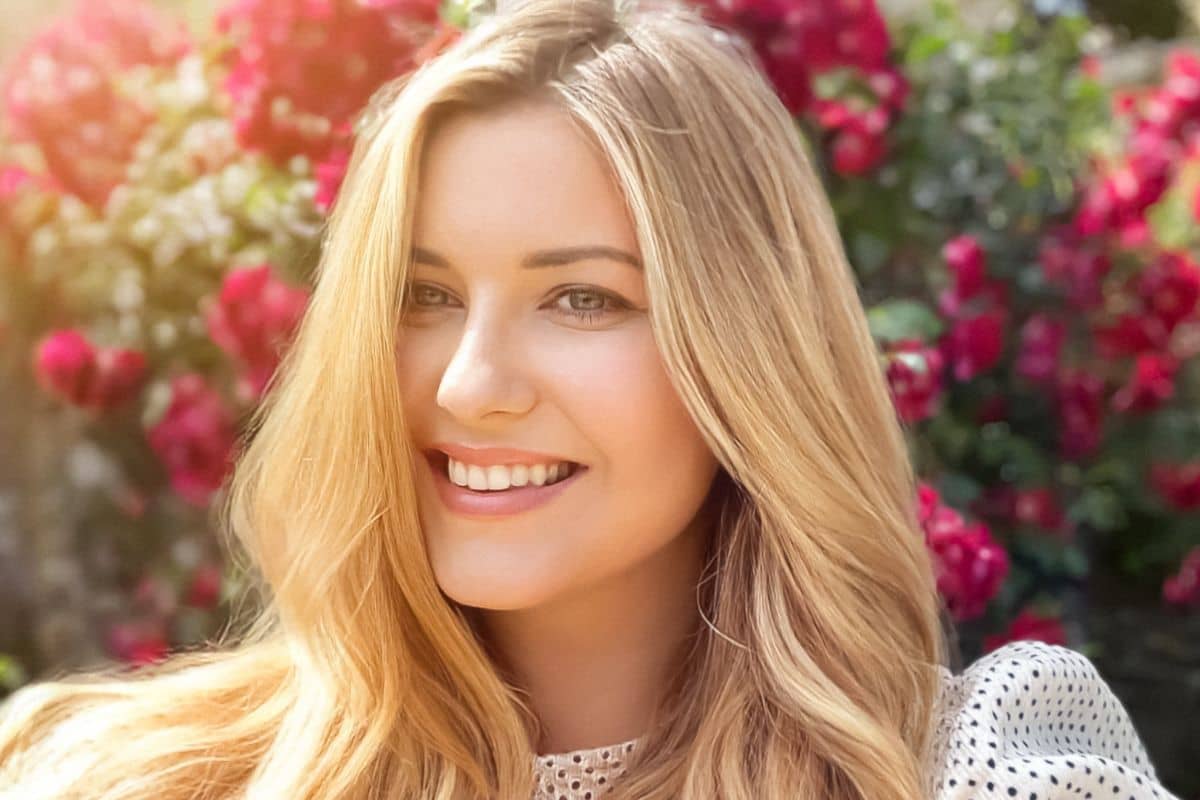 Smiling woman with smooth skin outdoors, representing natural-looking Botox results in Westfield NJ.