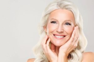 Smiling mature woman with smooth skin showing long-lasting results from a deep plane facelift procedure