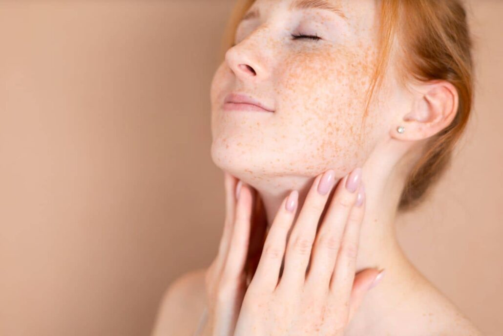 Woman touching jawline with smooth, refreshed skin, illustrating natural-looking results after Juvederm treatment