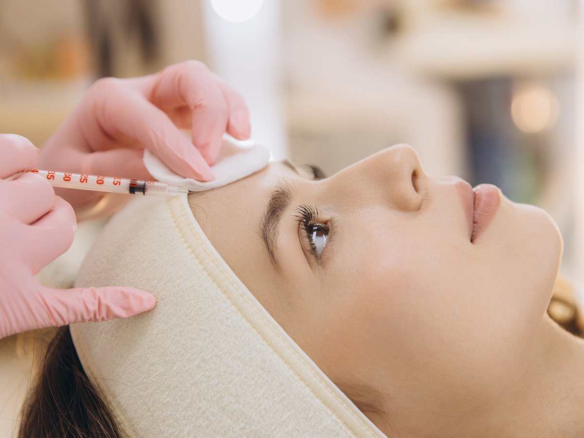 Practitioner administering Botox injection on forehead to reduce wrinkles and fine lines