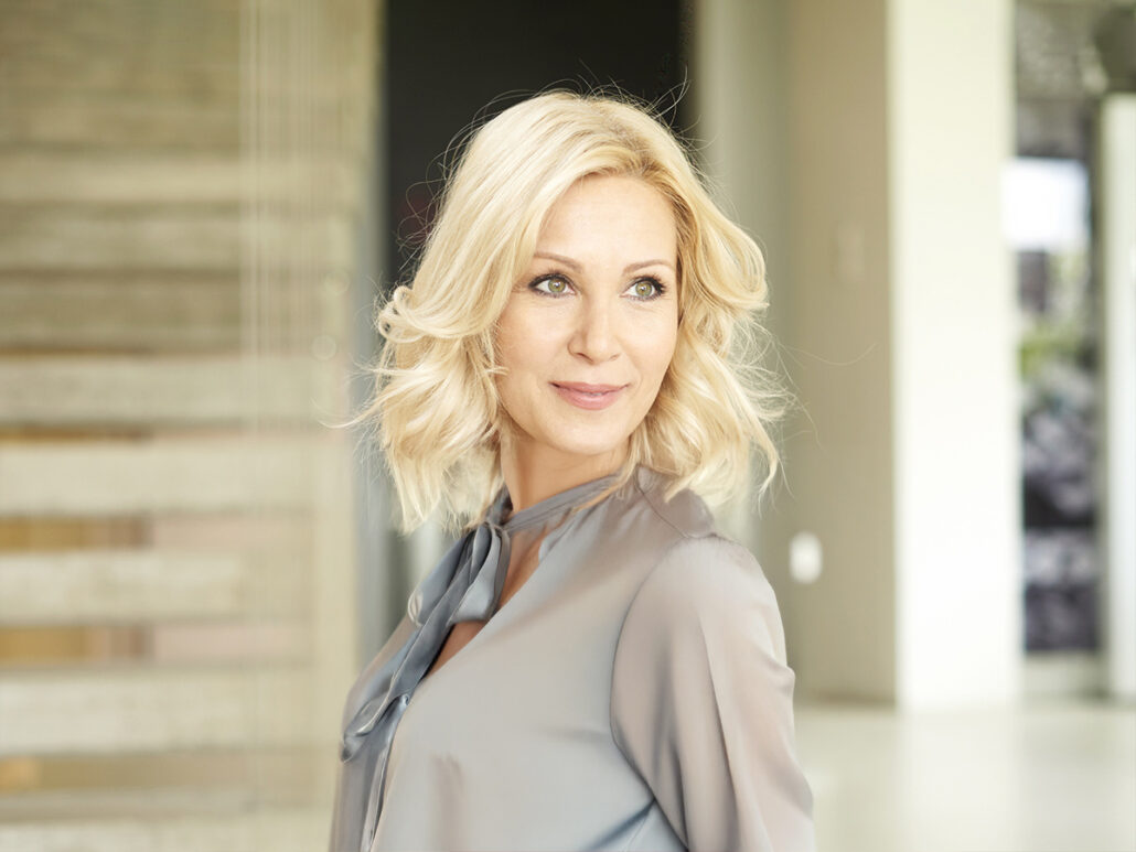 Woman with smooth, lifted facial appearance showcasing natural facelift results in a bright indoor setting