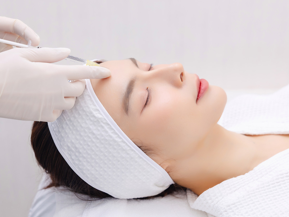 Patient receiving Botox injection on forehead to reduce wrinkles and smooth facial lines.