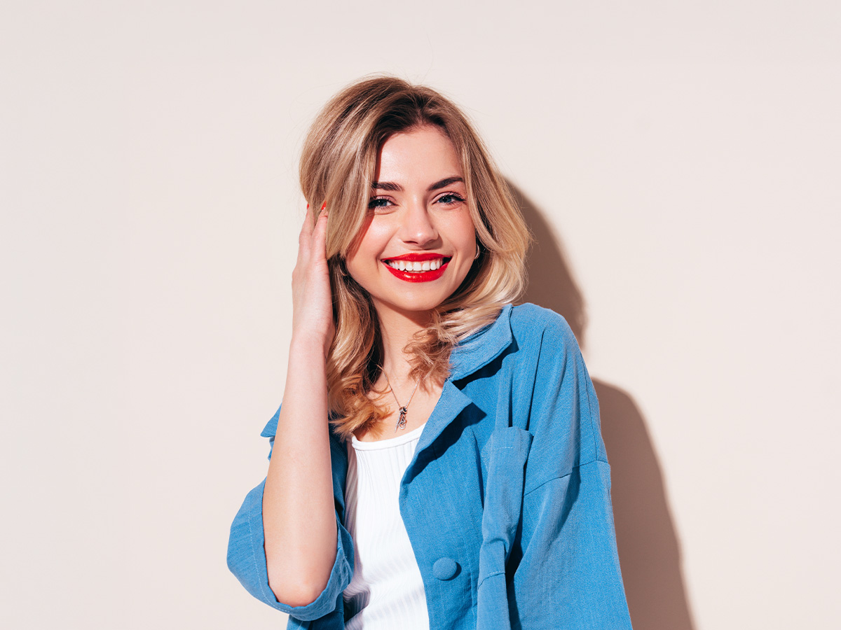 Smiling woman with defined chin and balanced facial features representing chin surgery results in New Jersey.