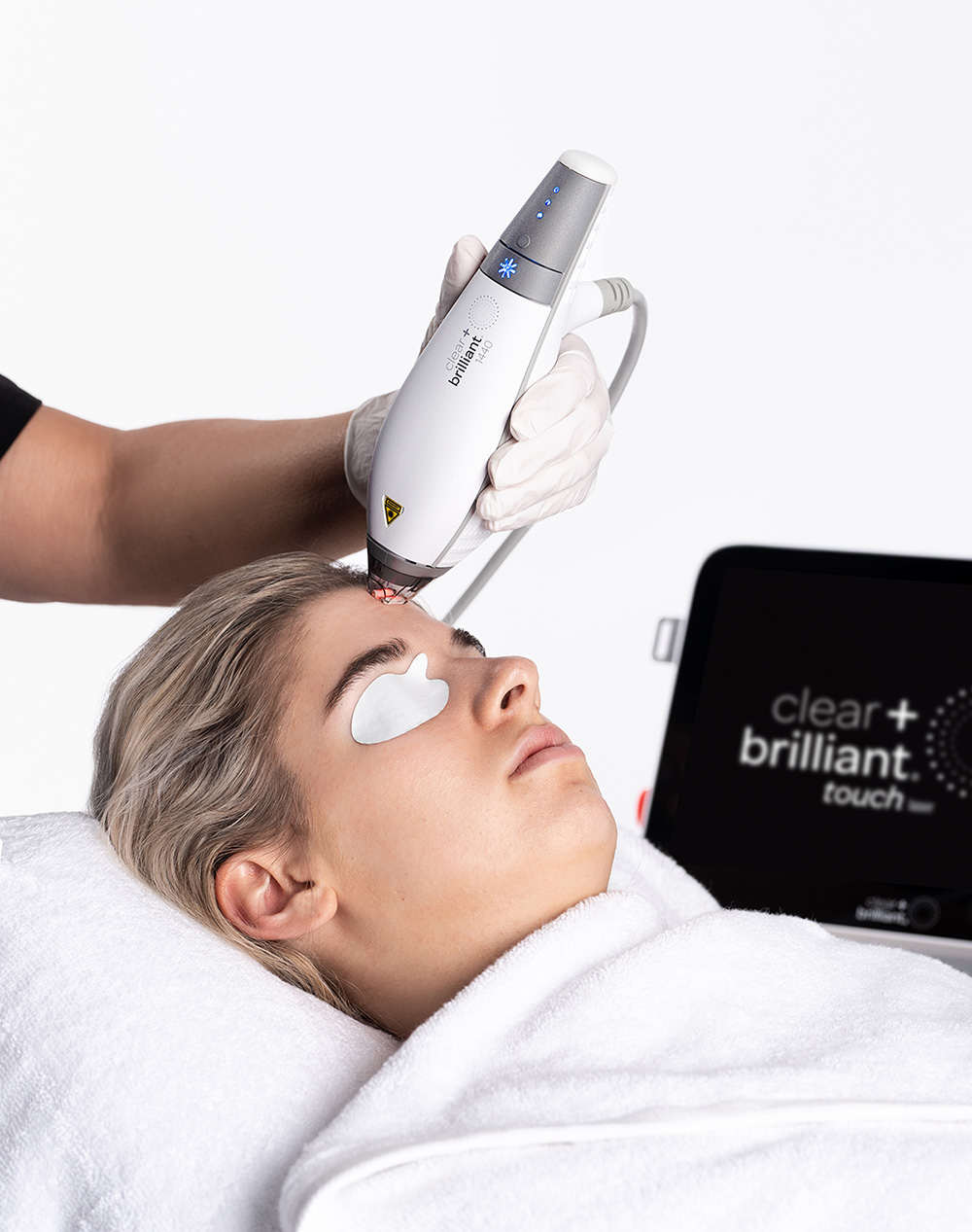 Patient receiving Clear and Brilliant laser illustrating ideal candidates for improving skin tone and early aging signs.