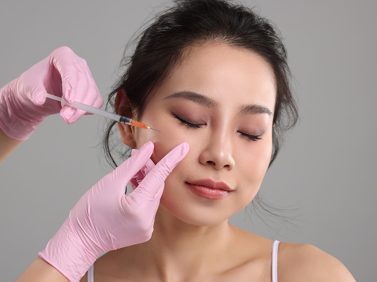 Practitioner administering Jeuveau injection on cheek to reduce facial wrinkles and smooth skin