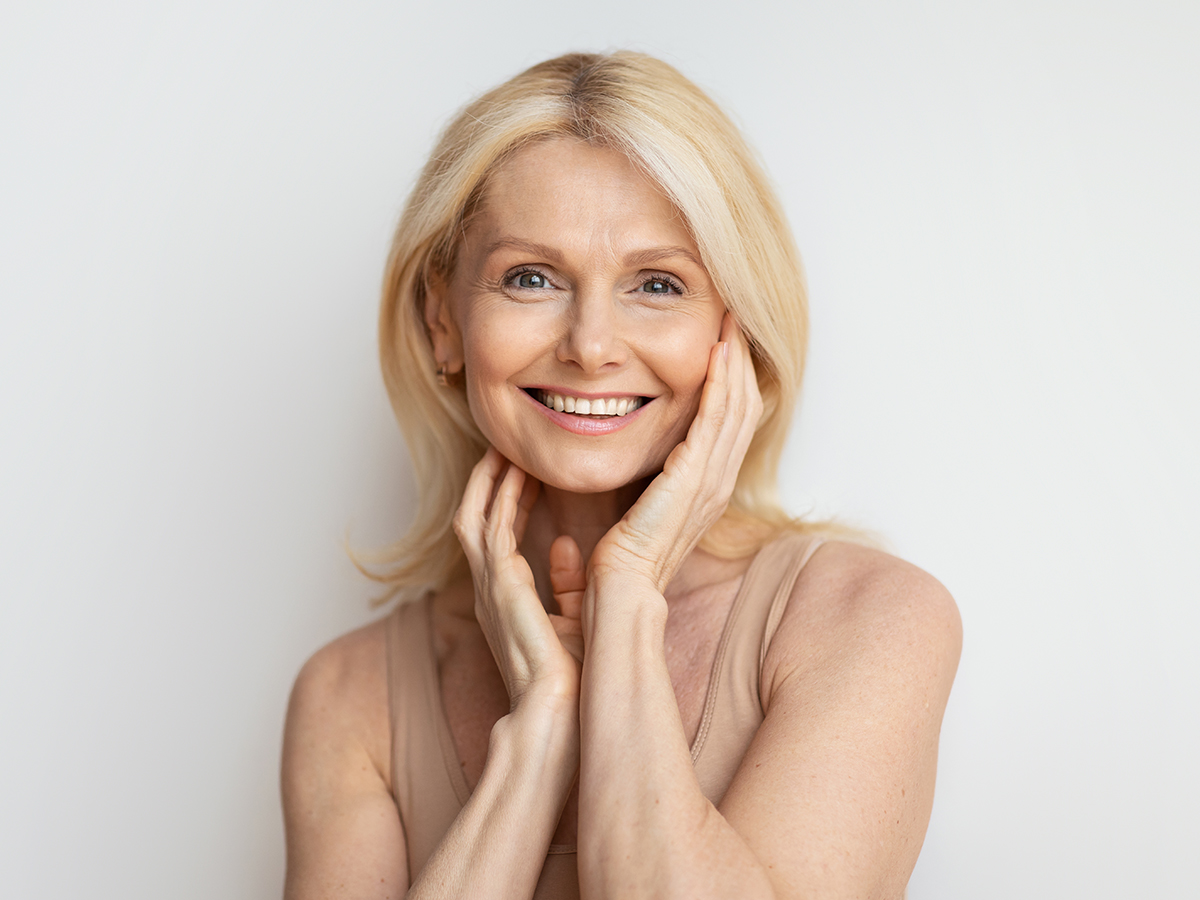 Smiling mature woman with smooth skin highlighting anti-aging results from laser resurfacing treatment