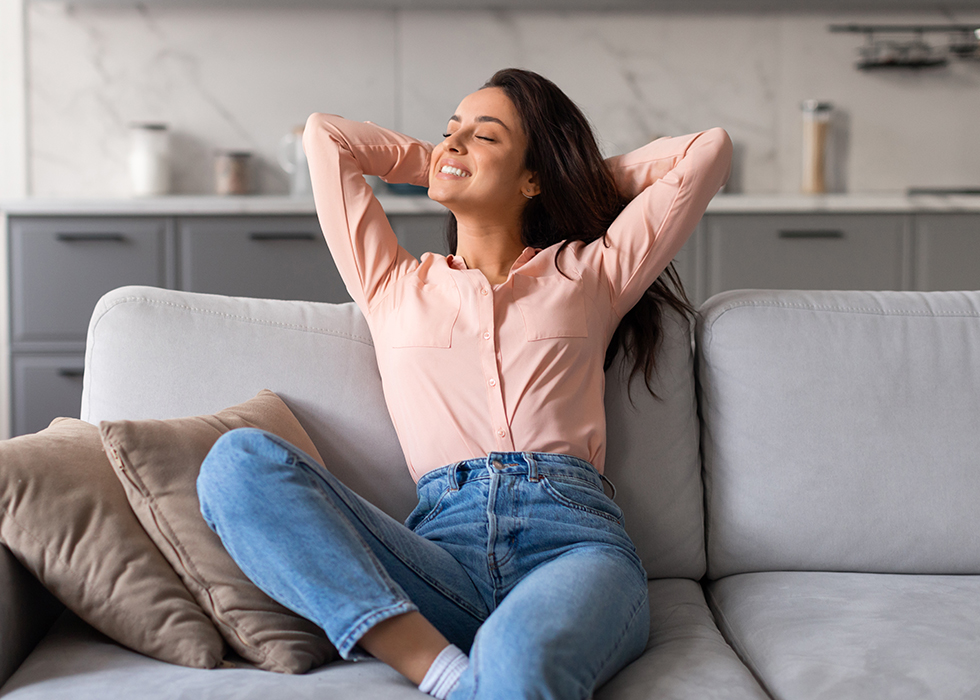 Woman relaxing comfortably at home during otoplasty recovery after ear surgery in New Jersey