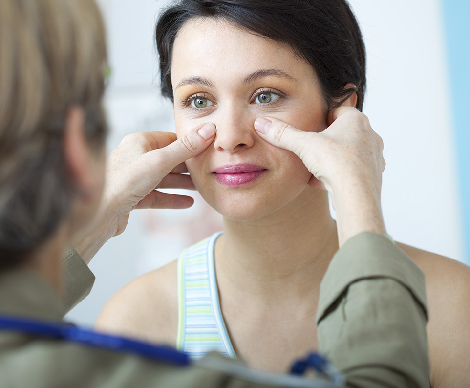 Doctor examining nasal area to assess sinus issues and deviated septum affecting breathing and airflow.