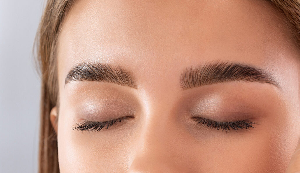 Close-up of eyebrows being groomed illustrating different brow lift techniques for smoother forehead and lifted brows.