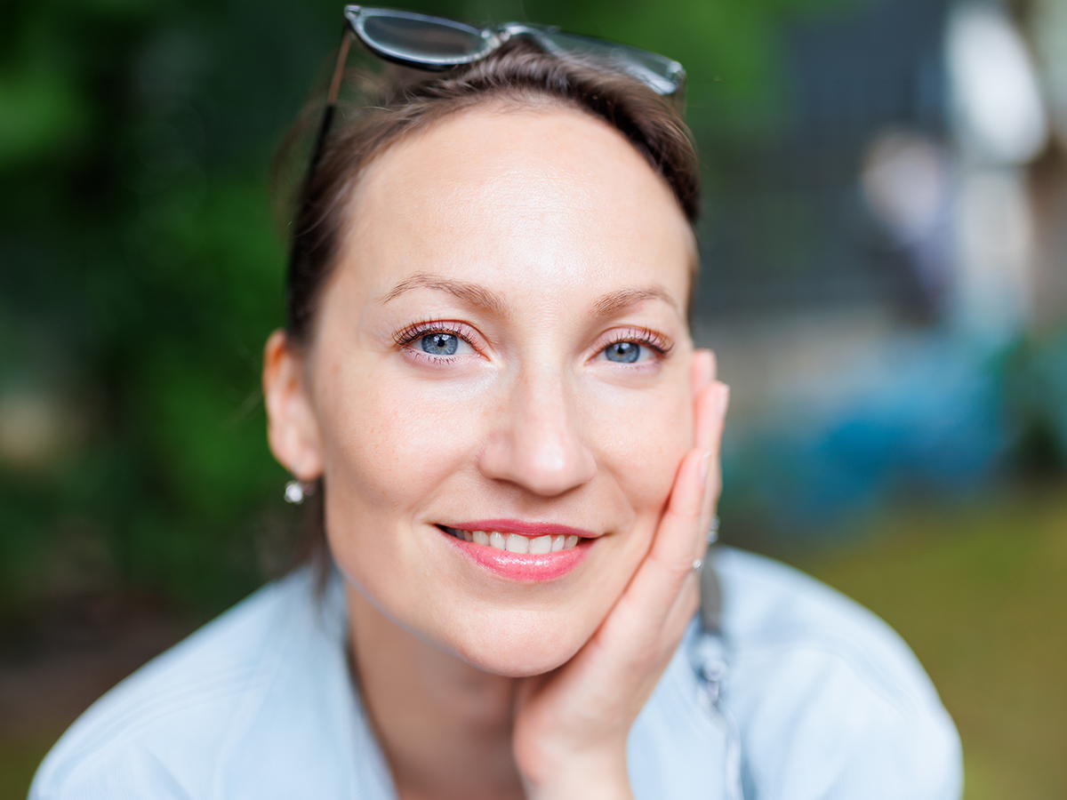 Smiling woman representing blepharoplasty benefits for refreshed eyes and eyelid comfort
