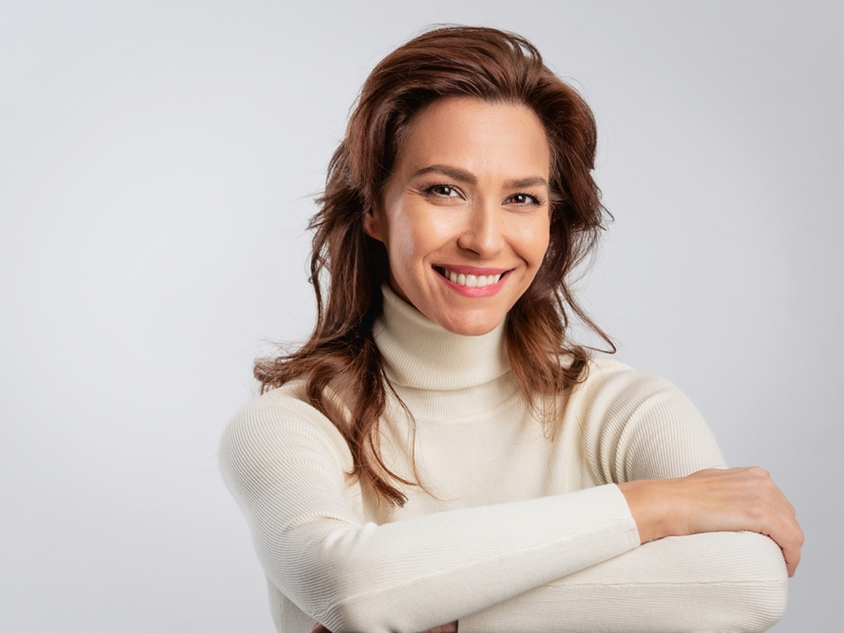 Smiling woman next to deep plane facelift explanation highlighting natural facial rejuvenation results.
