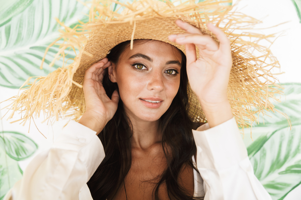 Woman in sun hat beside exosome results timeline explaining gradual skin renewal and lasting improvements.