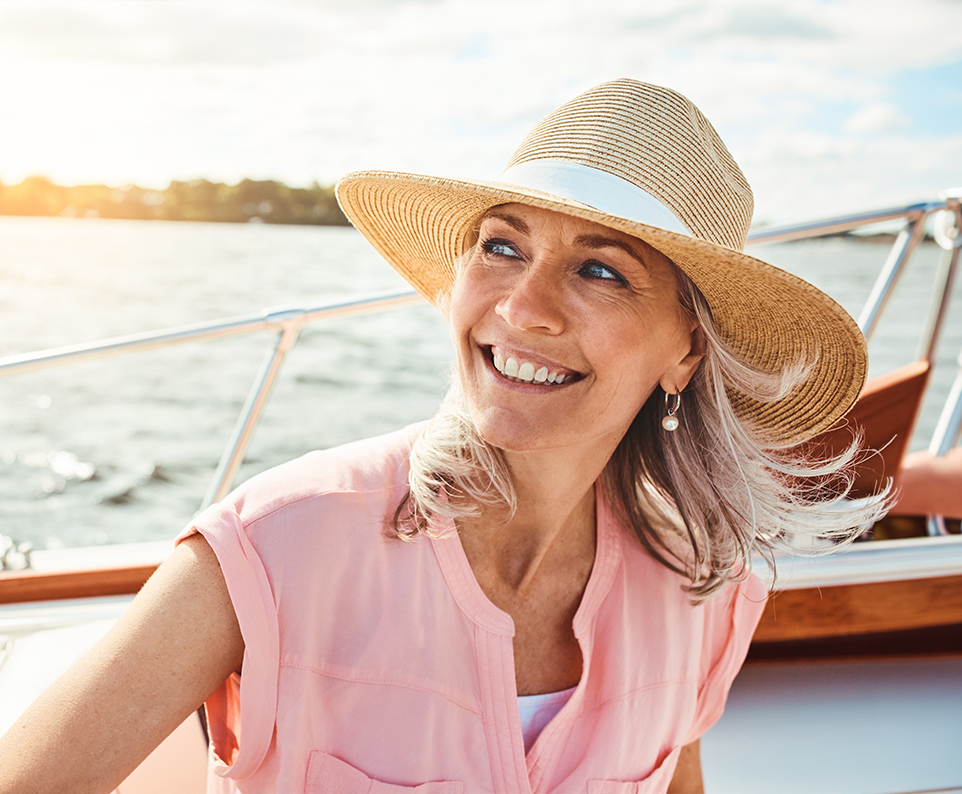 Smiling woman on a boat representing experienced facelift surgery for natural results and careful facial rejuvenation.