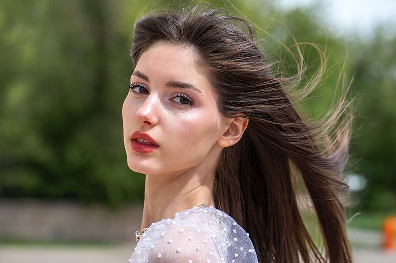 Woman outdoors representing facelift with neck lift for facial rejuvenation, neck contouring, and improved definition