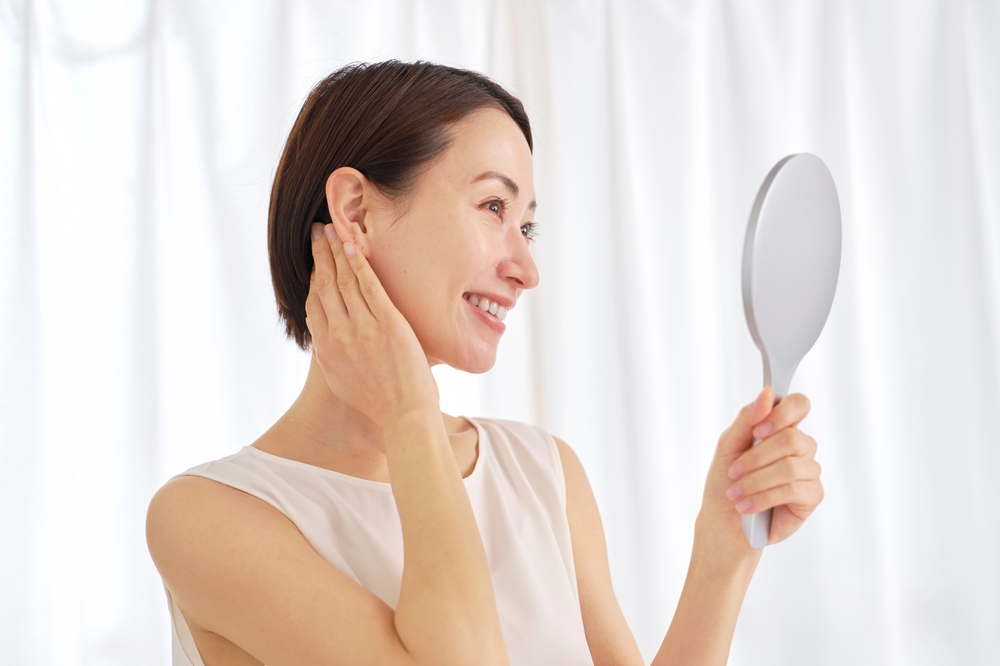 Woman using mirror beside nanofat scar healing content about growth factors and improved skin texture.