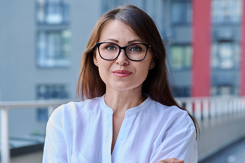 Woman with glasses representing mini facelift surgery for subtle mid-face and jawline refinement.