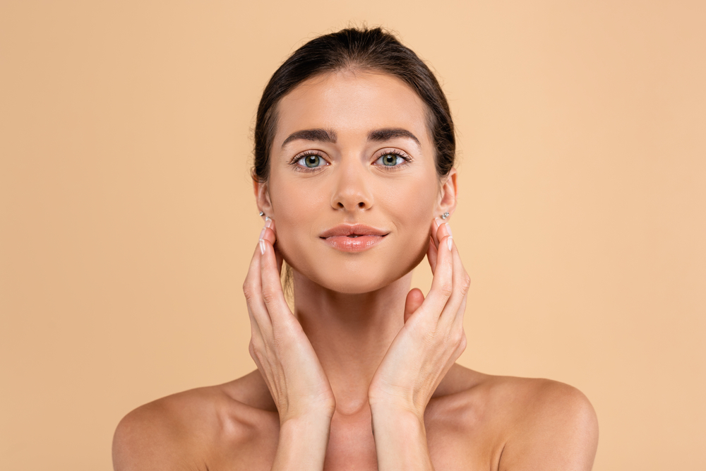 Young woman touching face beside PRP injections in New Jersey content for natural skin rejuvenation.