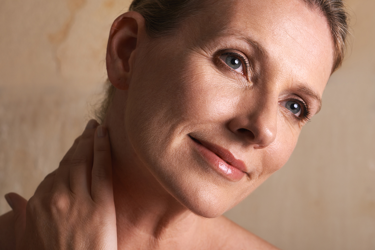 Mature woman beside what are exosomes content explaining cellular signals for skin repair and renewal.