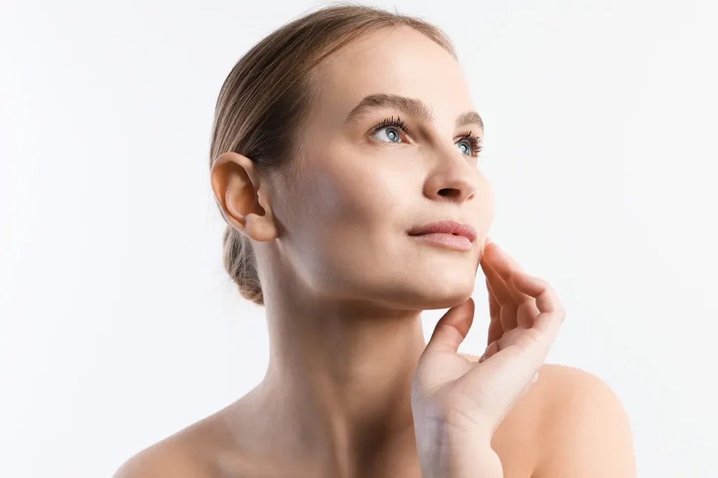 Woman examining smooth facial skin after cosmetic treatment.
